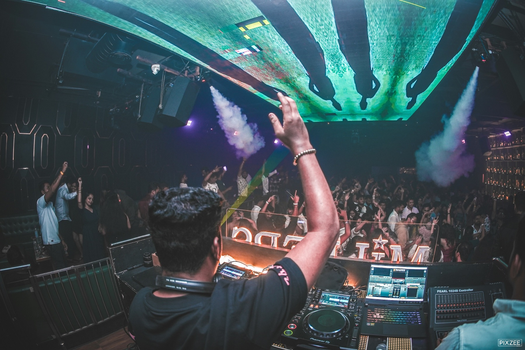 DJ performing in a neon-lit club